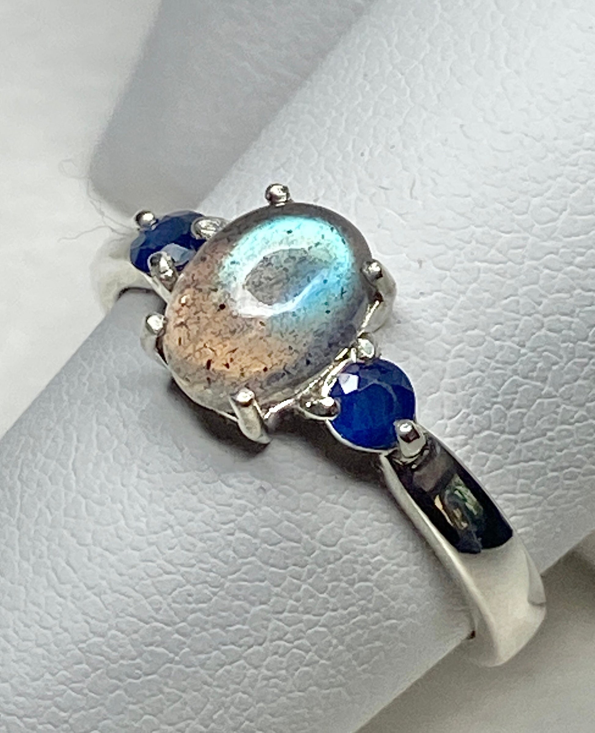 Sterling silver ring with oval labradorite and two blue sapphires.