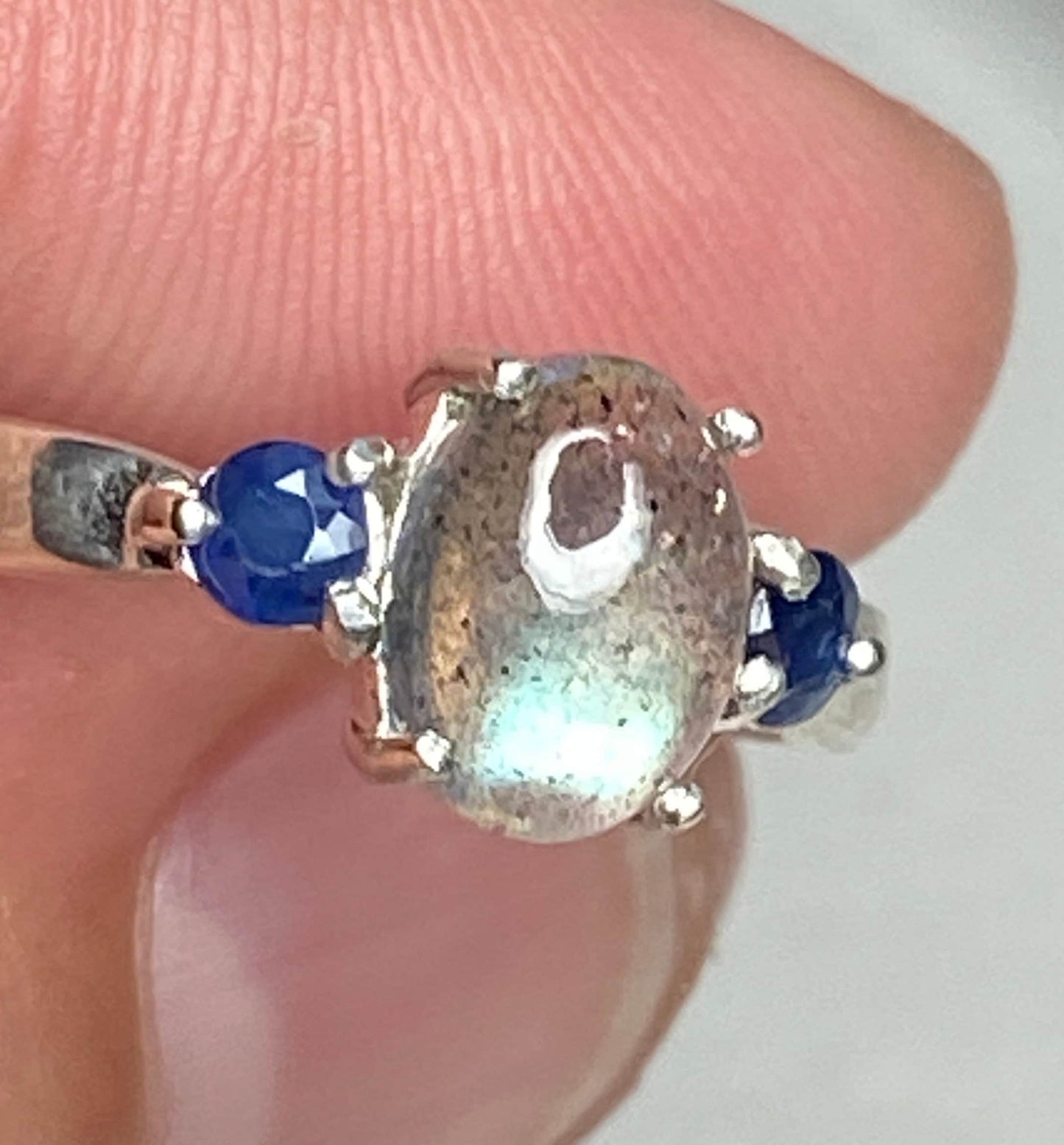 Sterling silver ring with oval labradorite and two blue sapphires.