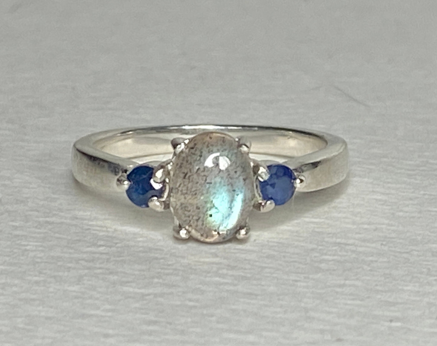 Sterling silver ring with oval labradorite and two blue sapphires.