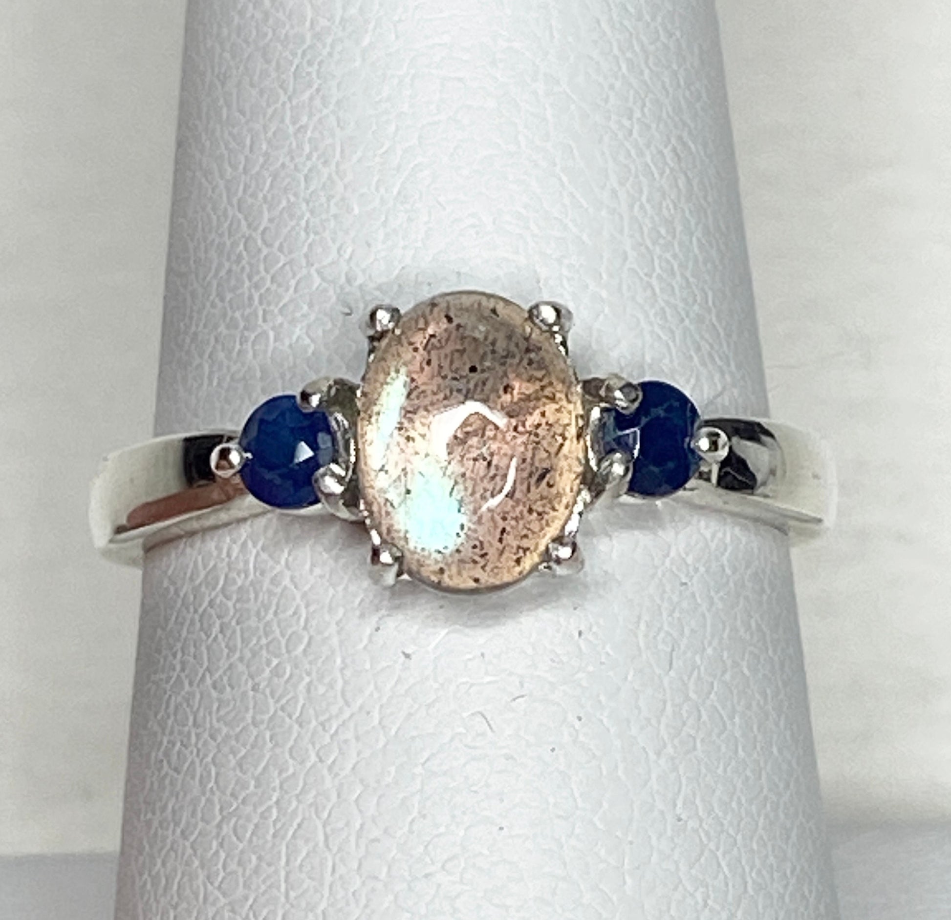 Sterling silver ring with oval labradorite and two round blue sapphires.