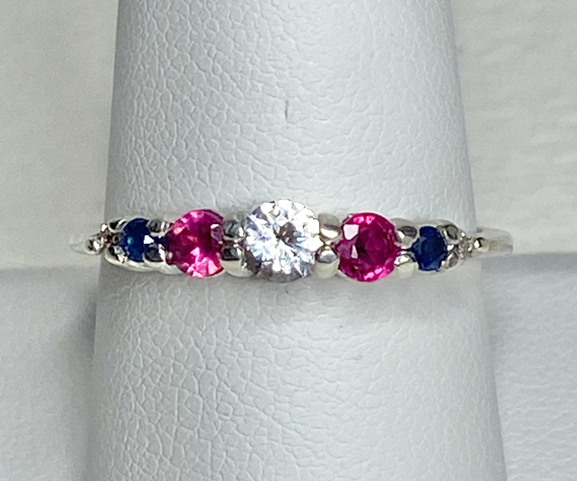 Sterling silver ring with a white sapphire, rubies, sapphires, and diamonds.