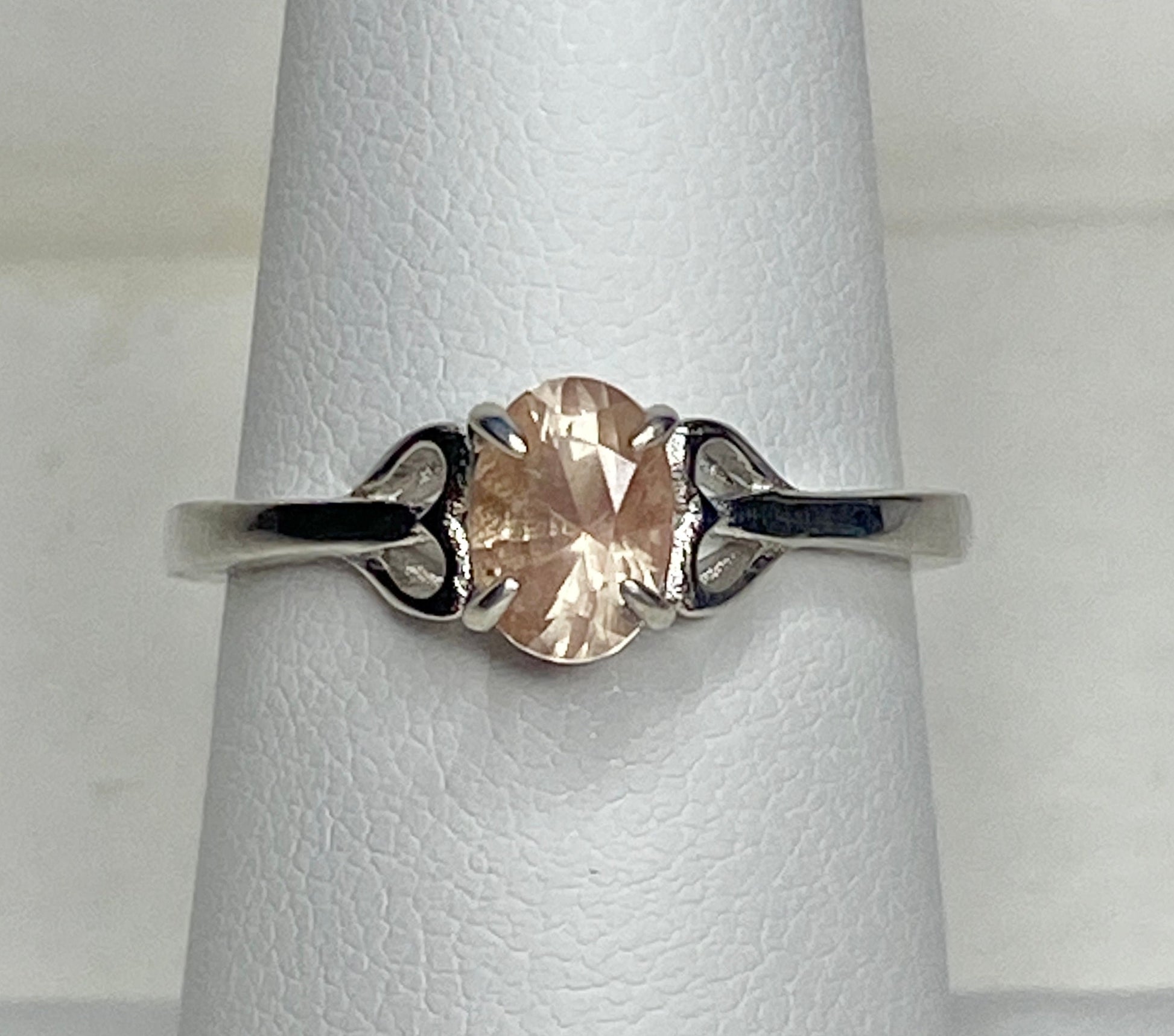 Sterling silver ring with a light peach oval Oregon sunstone and heart-shaped accents.