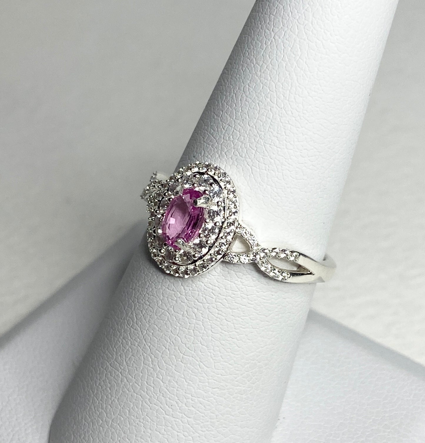 Sterling silver ring with oval pink sapphire and double halo of zircon.