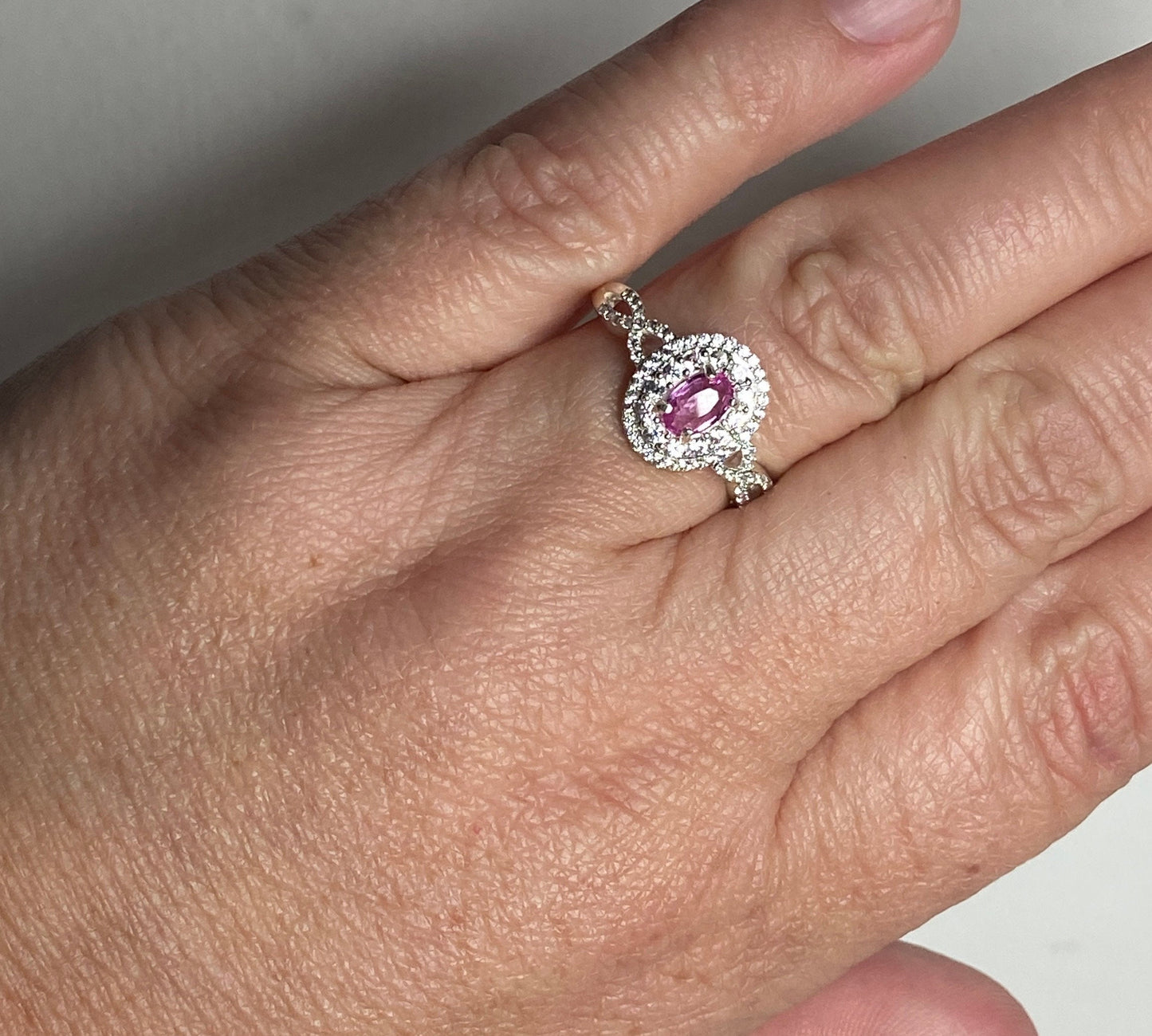 Oval pink sapphire and zircon double halo ring in sterling silver.