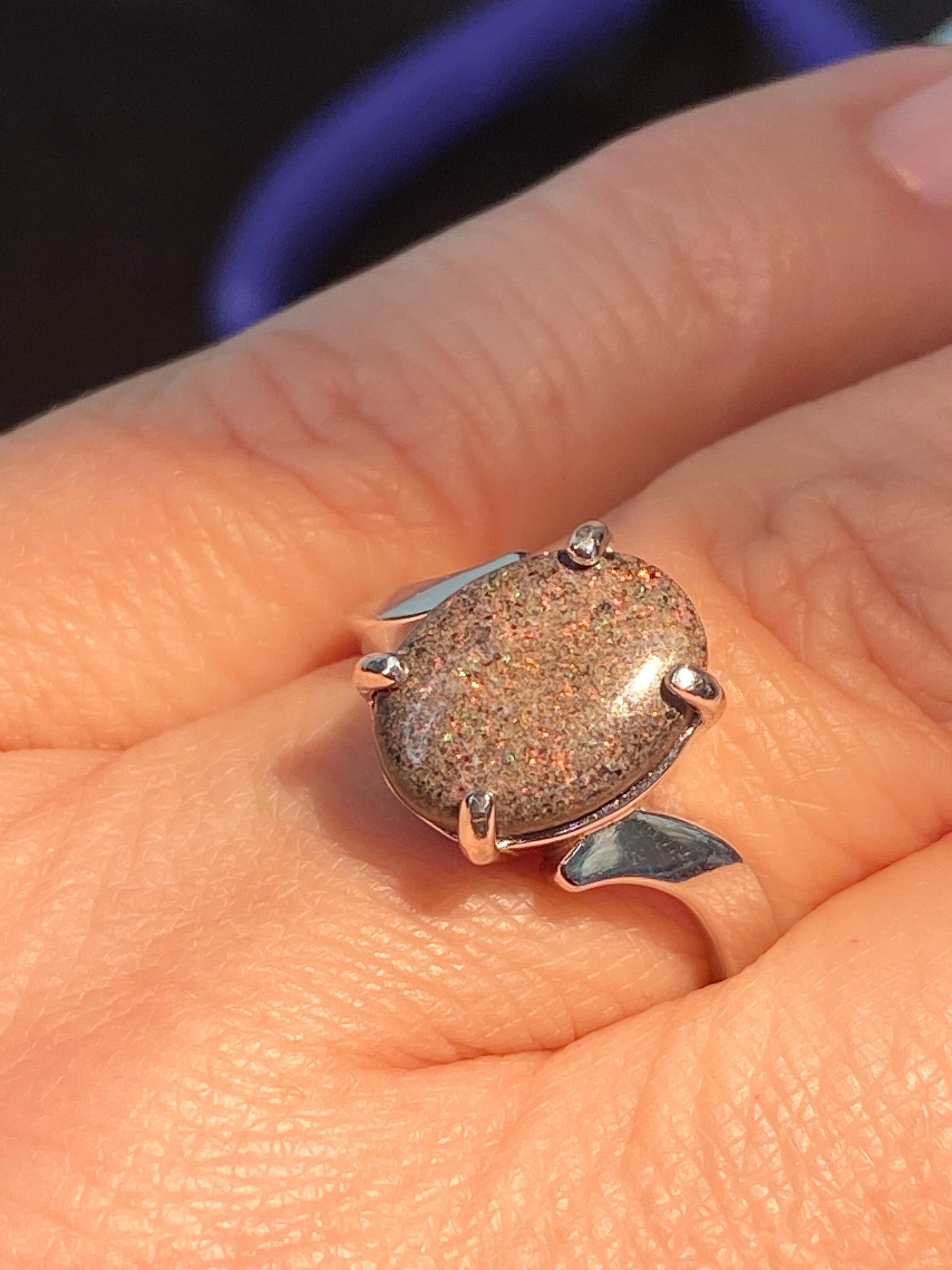 Sterling silver ring with a glittery pinfire boulder opal cabochon.