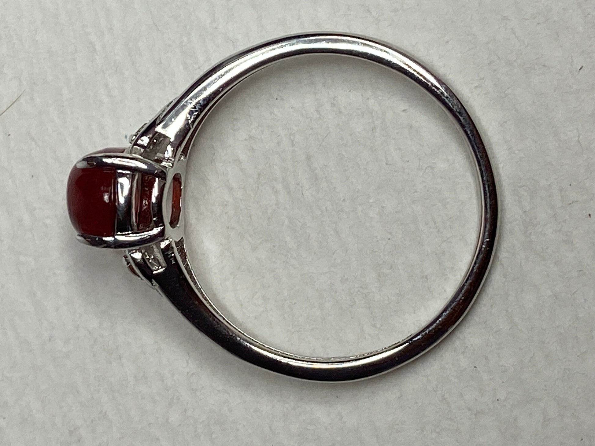 Sterling silver ring with a red oval sunstone and small brown diamonds.