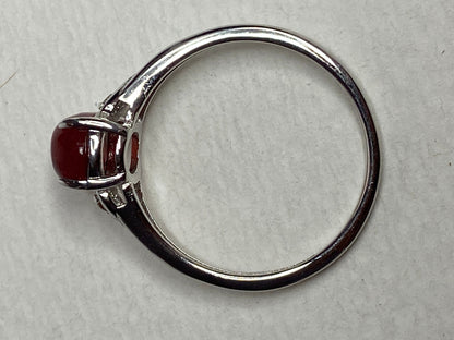 Sterling silver ring with a red oval sunstone and small brown diamonds.