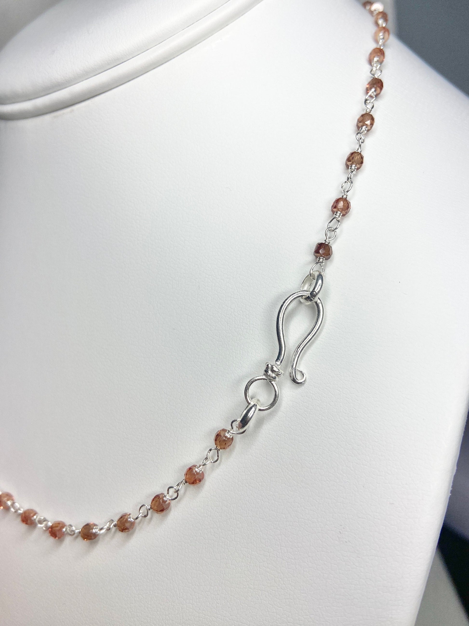 Sterling silver necklace with faceted brown zircon beads and a hook clasp.