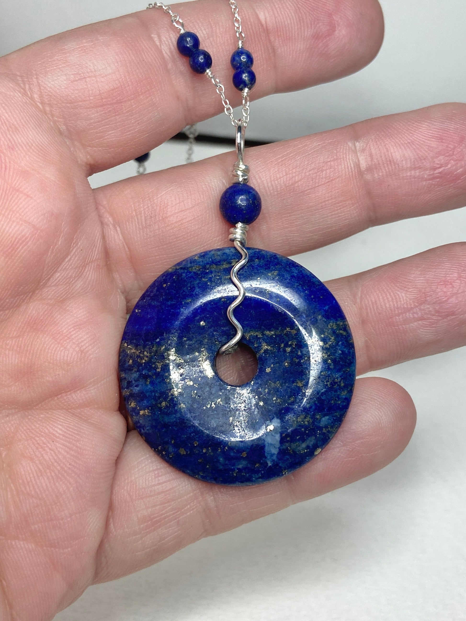 Lapis lazuli sterling silver donut pendant necklace with beaded chain.
