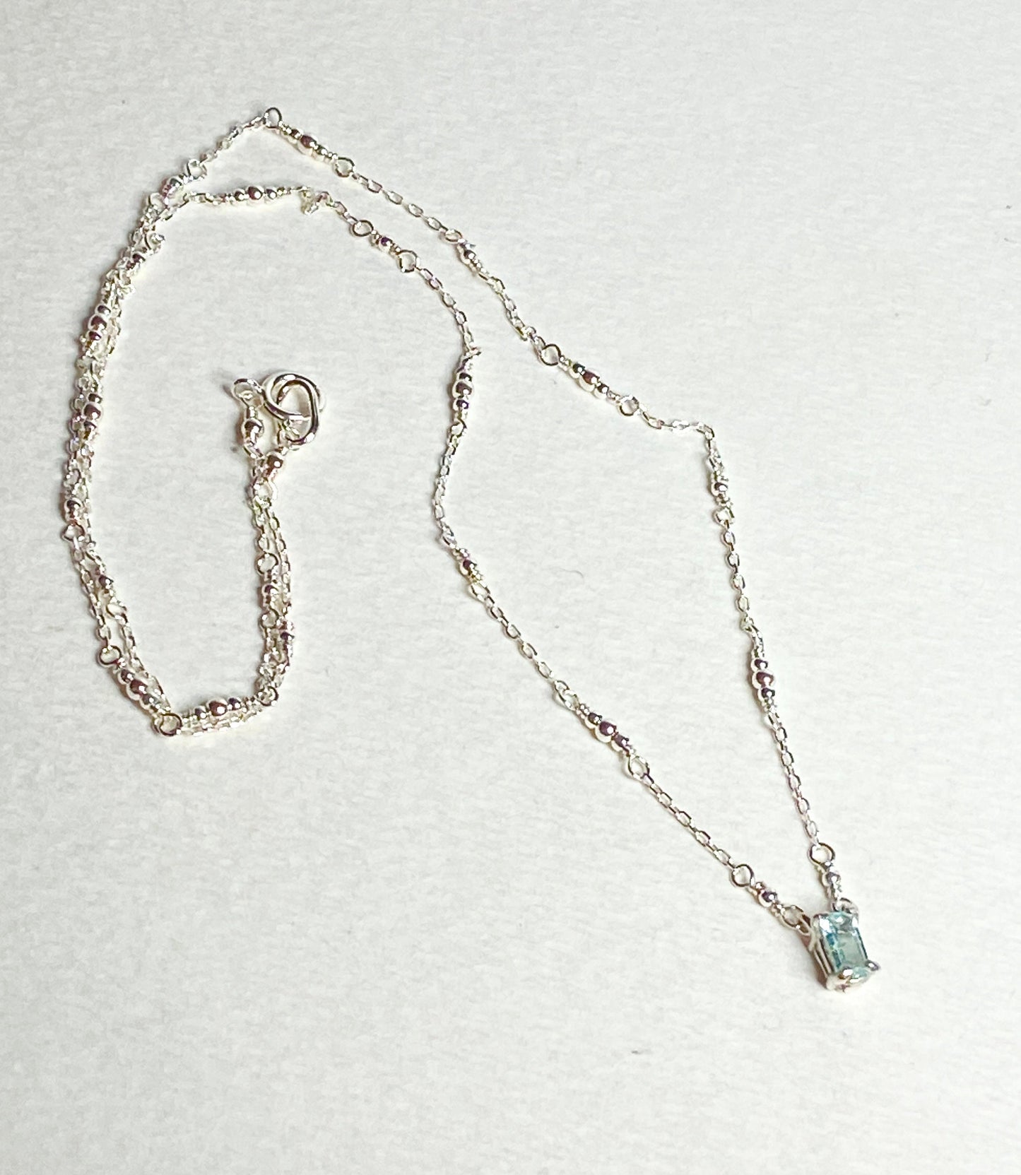 Sterling silver necklace with a rectangular cuprian tourmaline pendant.