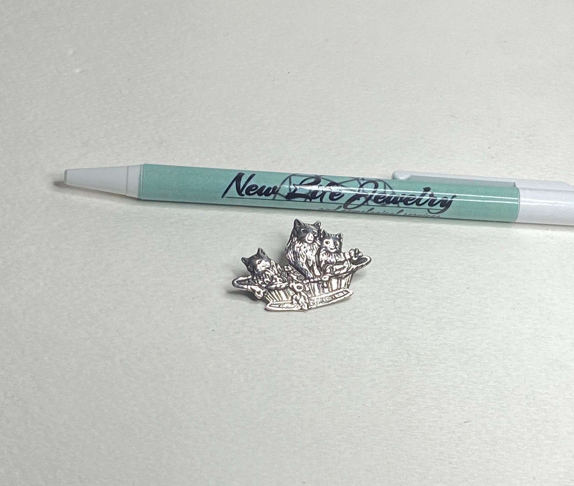 Sterling silver brooch pendant of three cats in a basket.
