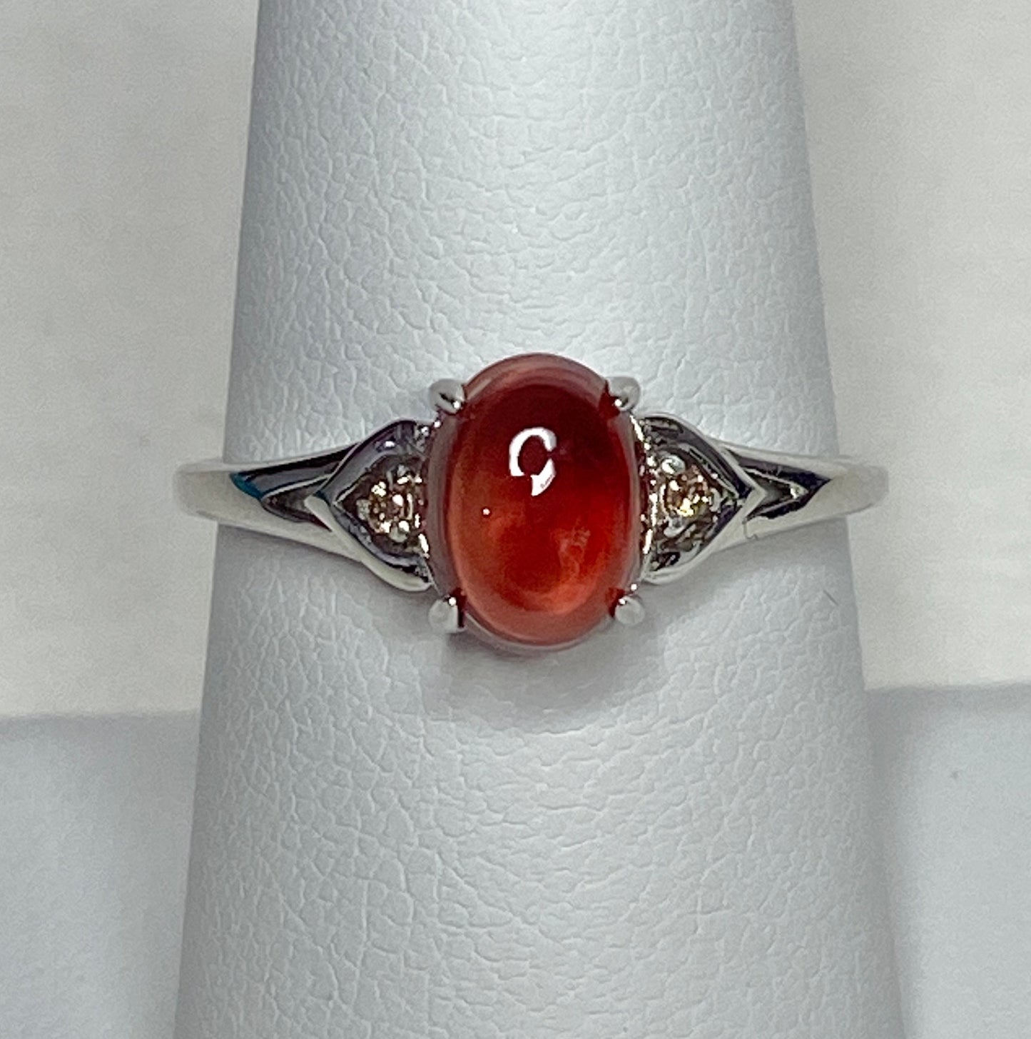 Sterling silver ring with oval red Oregon sunstone and small brown diamonds.