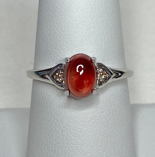 Sterling silver ring with oval red Oregon sunstone and small brown diamonds.