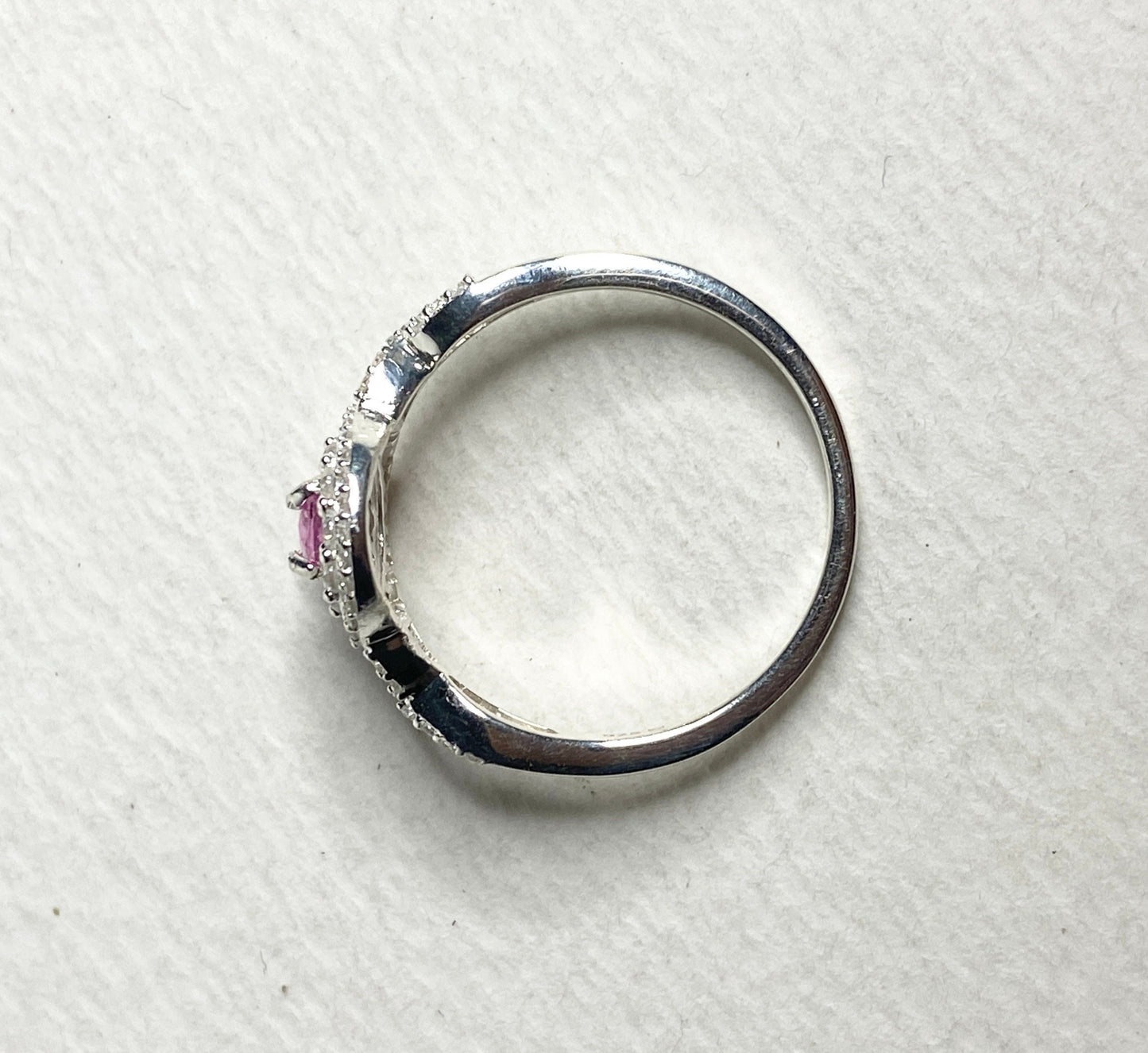 Sterling silver ring with a pink sapphire and double zircon halo.