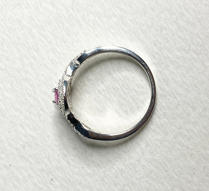 Sterling silver ring with a pink sapphire and double zircon halo.