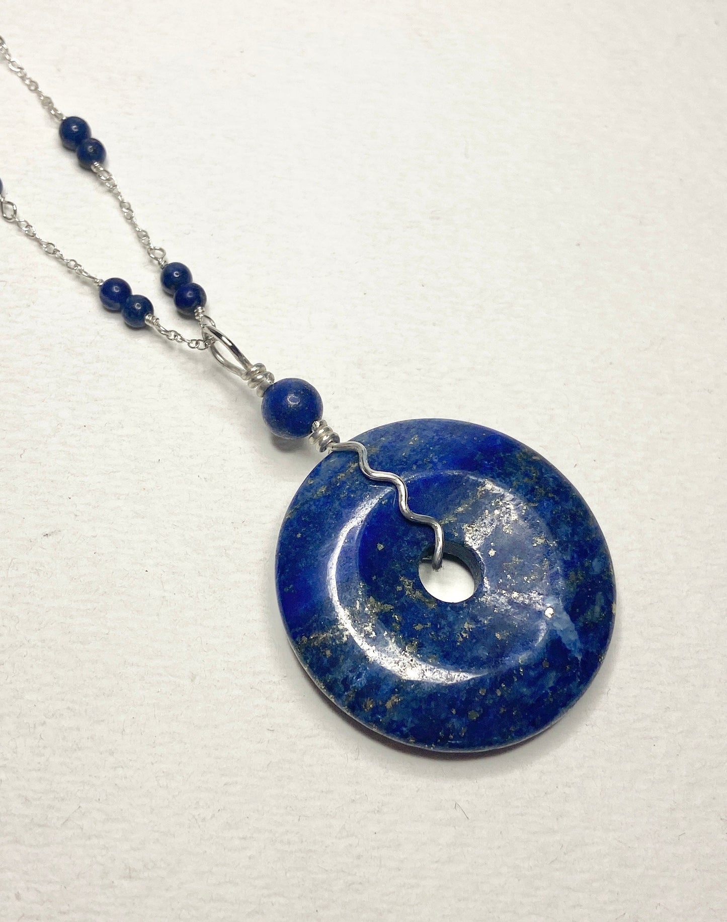 Lapis lazuli donut pendant necklace with sterling silver chain and beads.