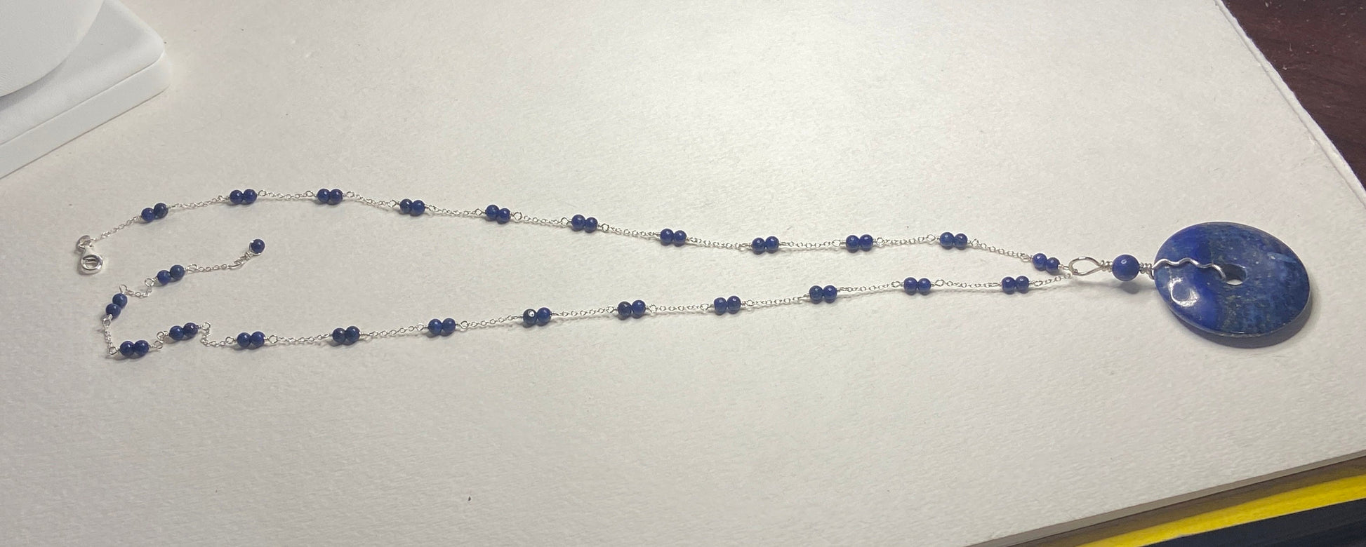 Sterling silver necklace with lapis lazuli beads and a removable donut pendant.