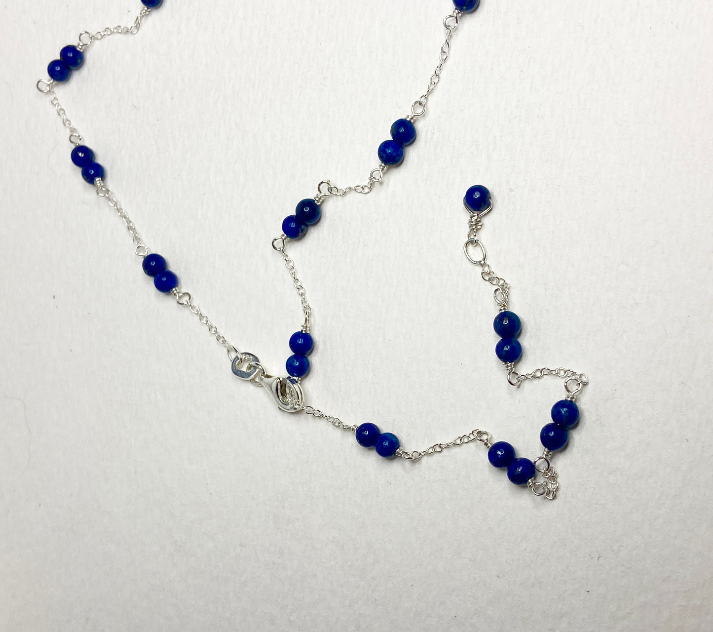 Sterling silver necklace with lapis lazuli beads and a removable donut pendant.
