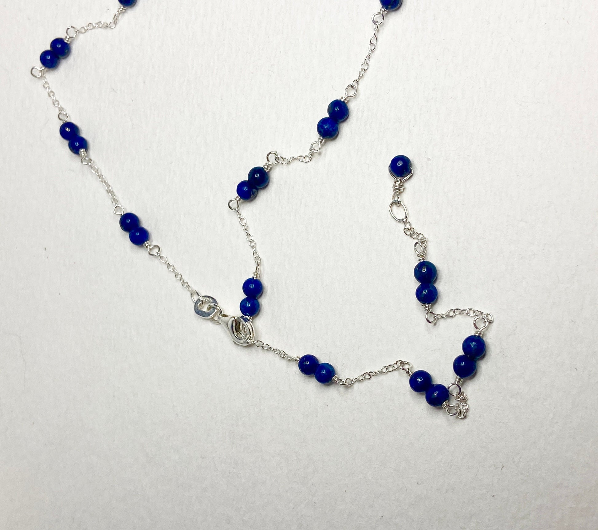 Sterling silver necklace with lapis lazuli beads and a removable donut pendant.