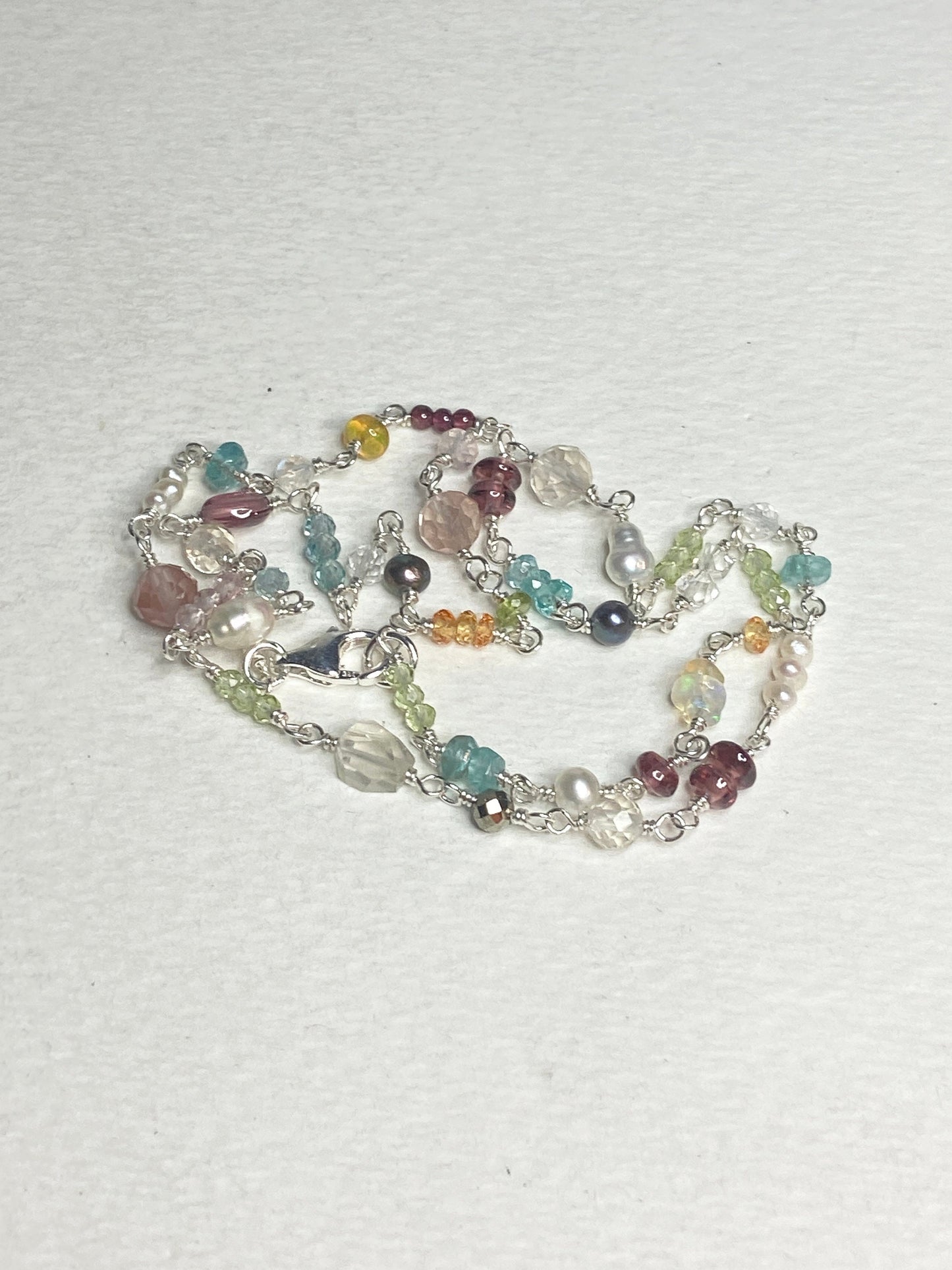 Sterling silver necklace with a variety of colorful natural gemstones and pearls.