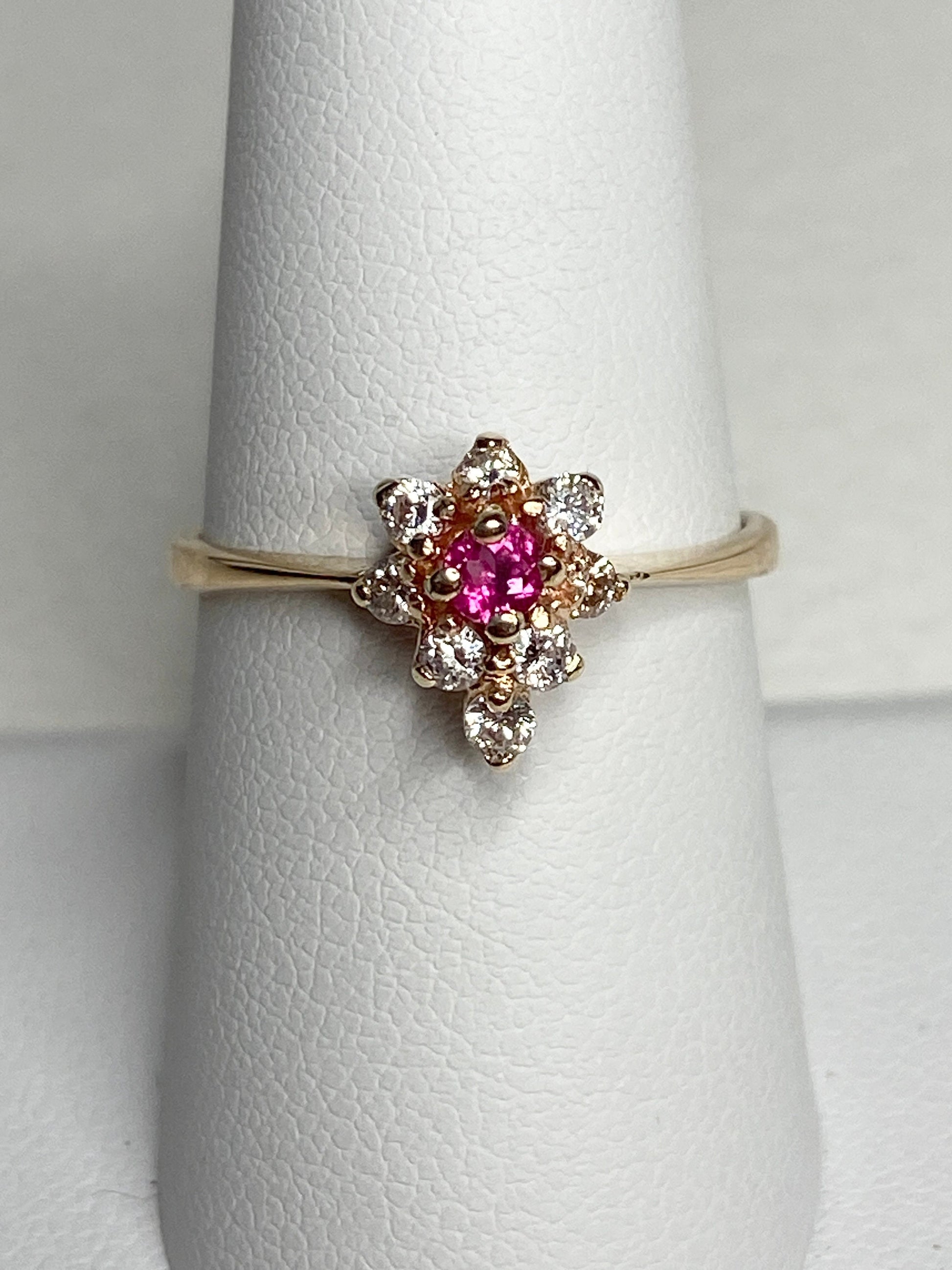 A 14k gold ring with a pink rubellite tourmaline center and surrounding diamonds.