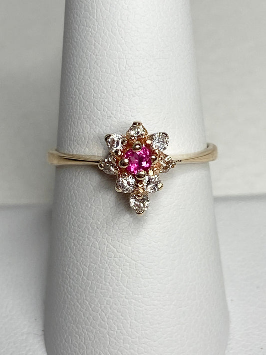 A 14k gold ring with a pink rubellite tourmaline center and surrounding diamonds.