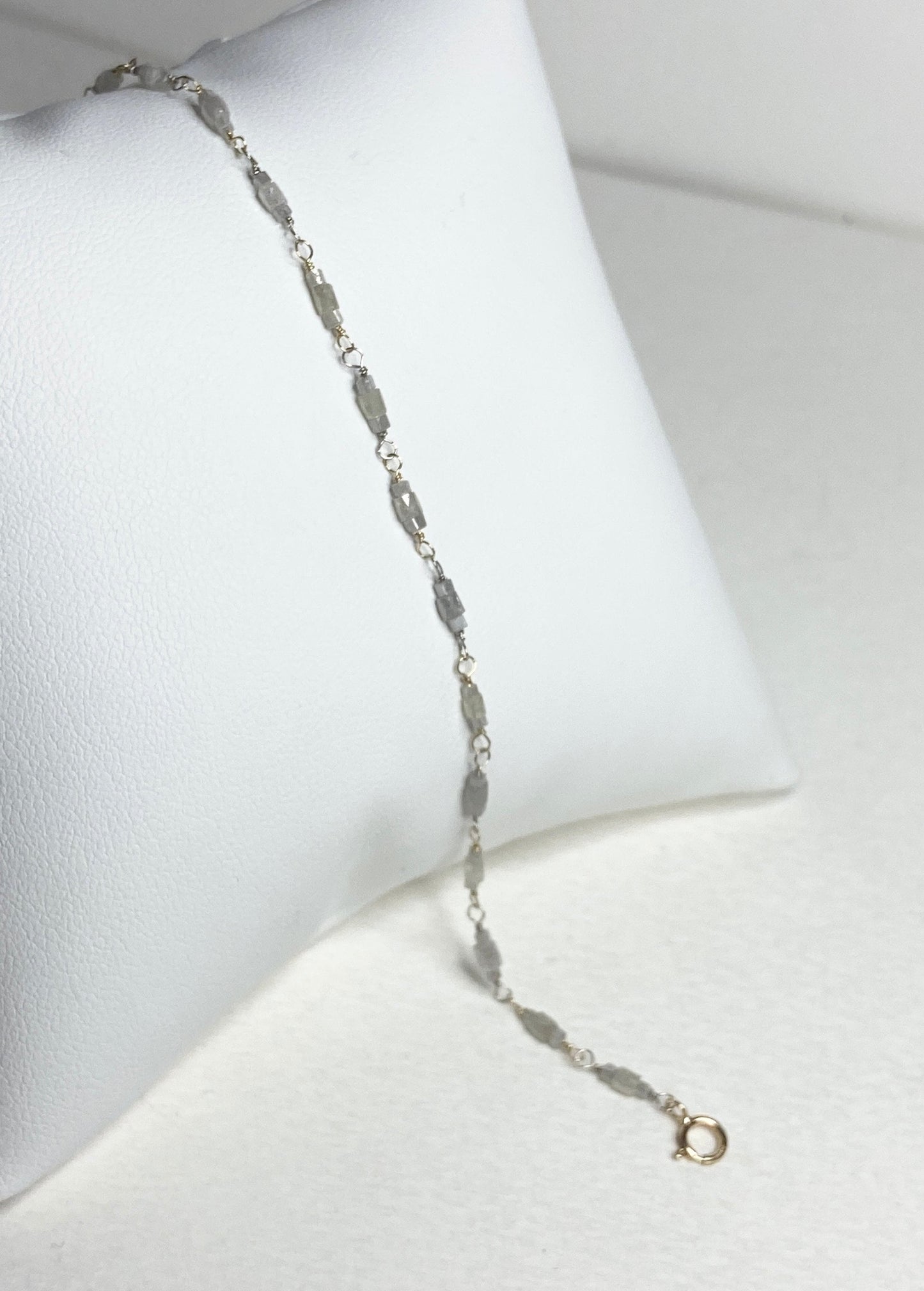 A delicate bracelet with faceted diamond beads and gold links.