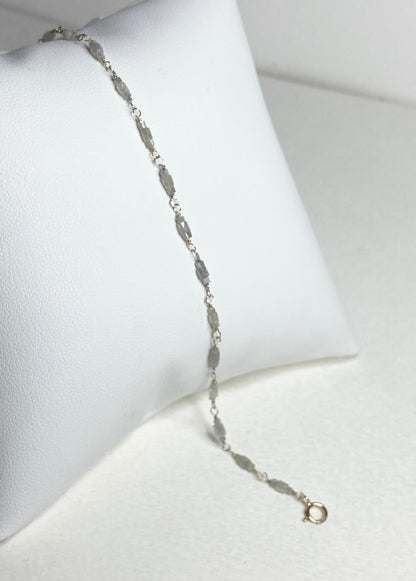 A delicate bracelet with faceted diamond beads and gold links.