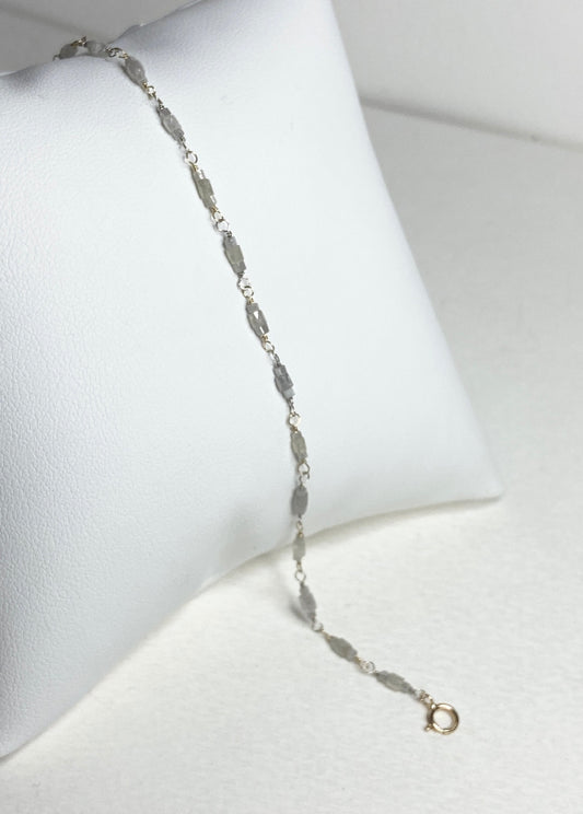 A delicate bracelet with faceted diamond beads and gold links.