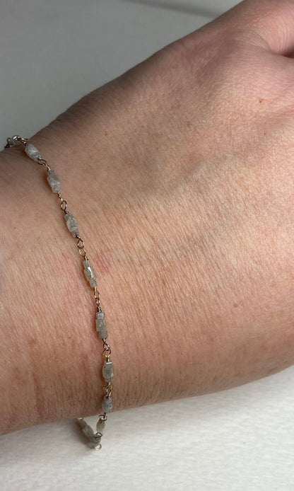 A delicate bracelet with raw, faceted diamonds and gold wire accents.