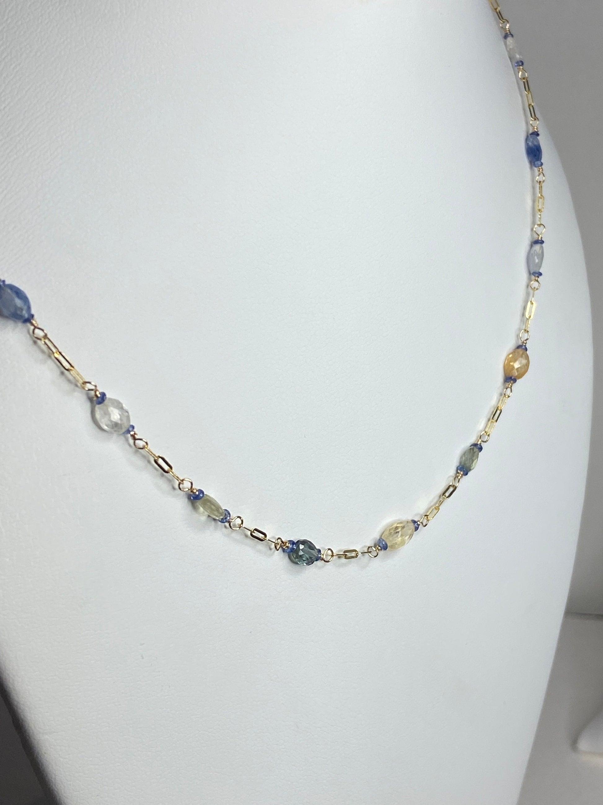 A 14k gold station chain necklace with multi-colored untreated sapphires.