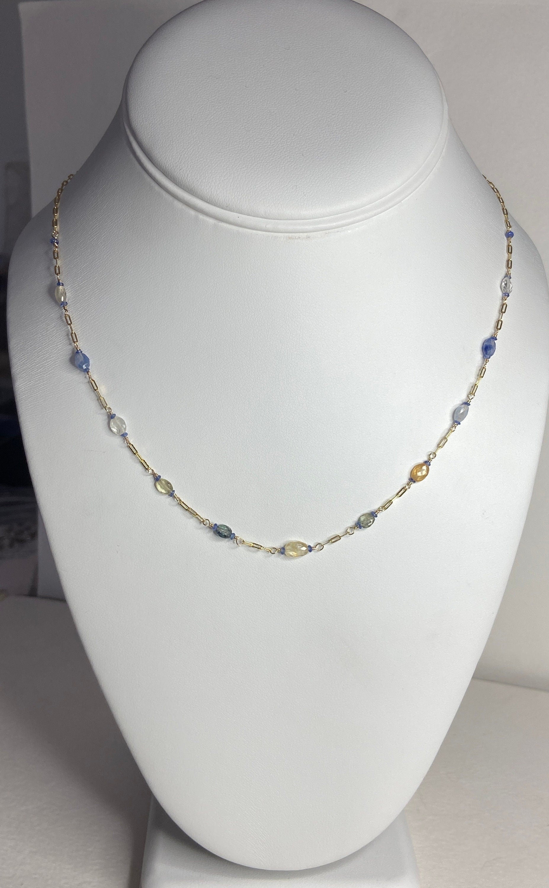 A 14k gold station chain necklace with multi-colored sapphires.