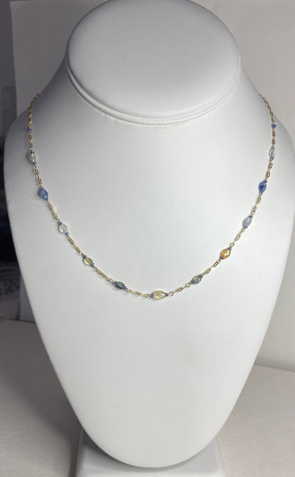A 14k gold station chain necklace with multi-colored sapphires.