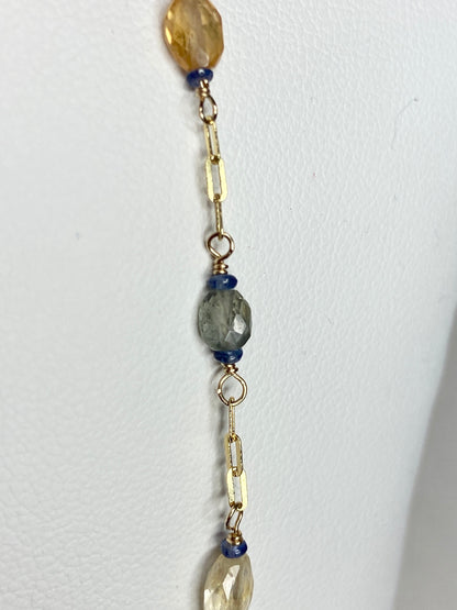 A 14k gold station chain necklace with multi-colored sapphires.