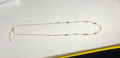 A 14k gold station chain necklace with multi-colored sapphires.
