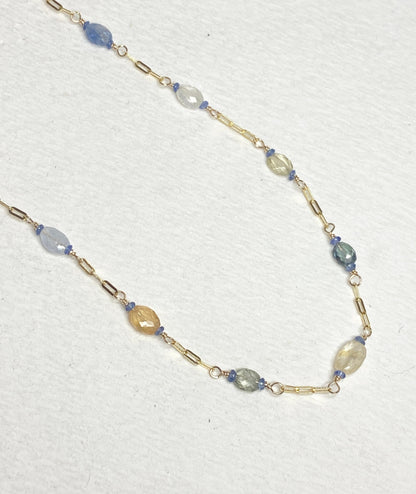 A 14k gold station chain necklace with multi-colored sapphires.