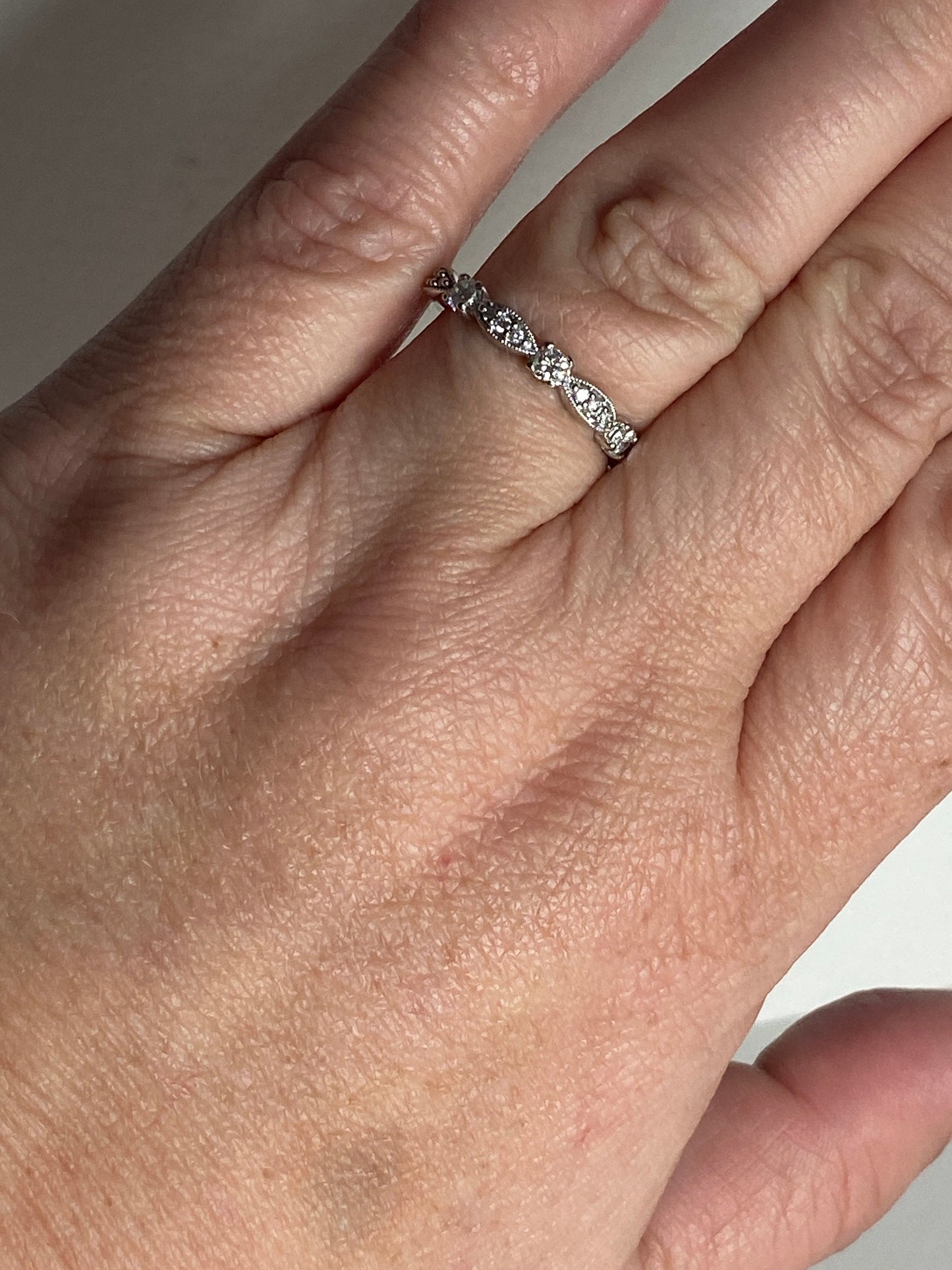 A delicate 10k white gold band ring with small diamonds.