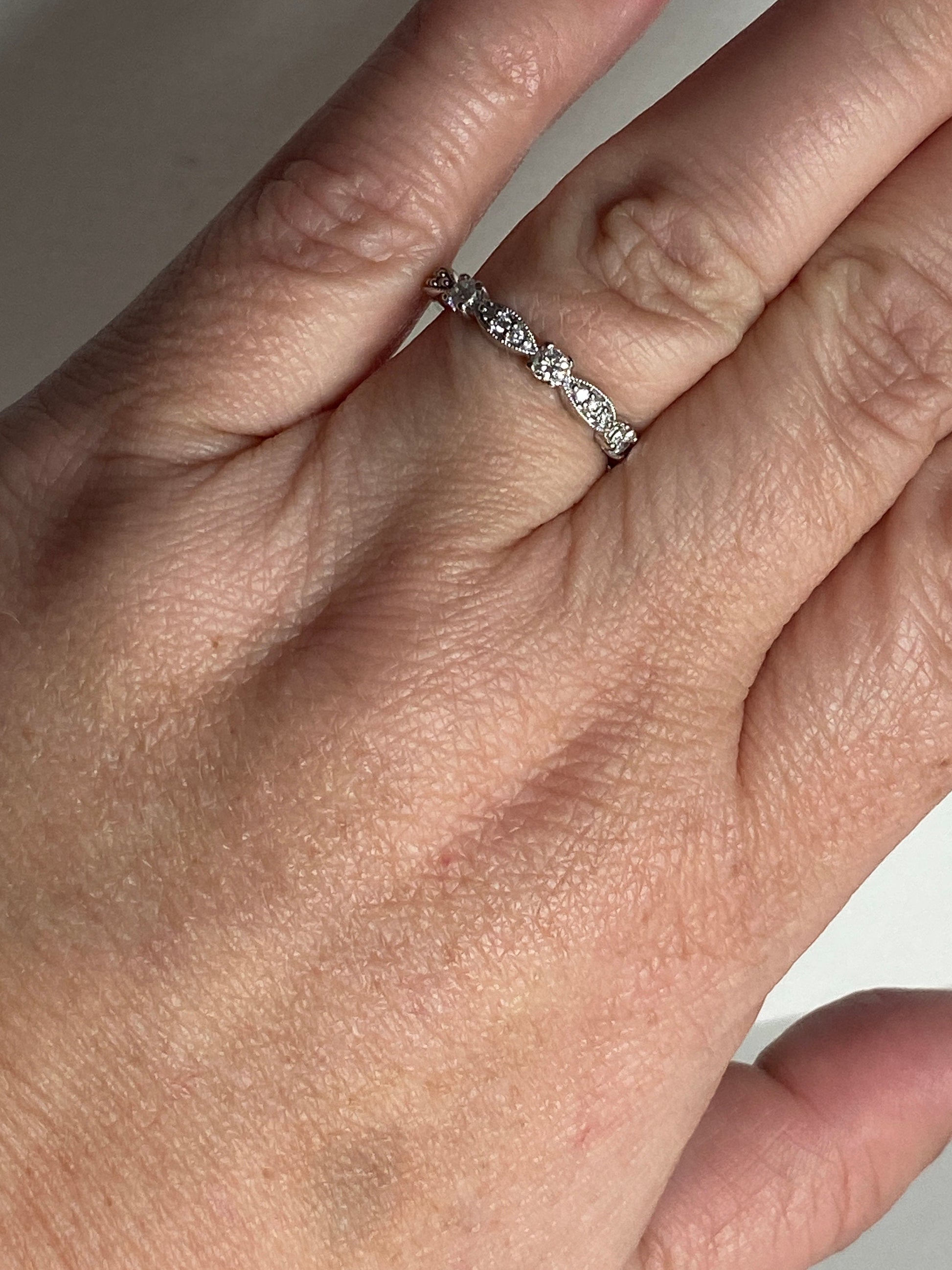 A delicate 10k white gold band ring with small diamonds.