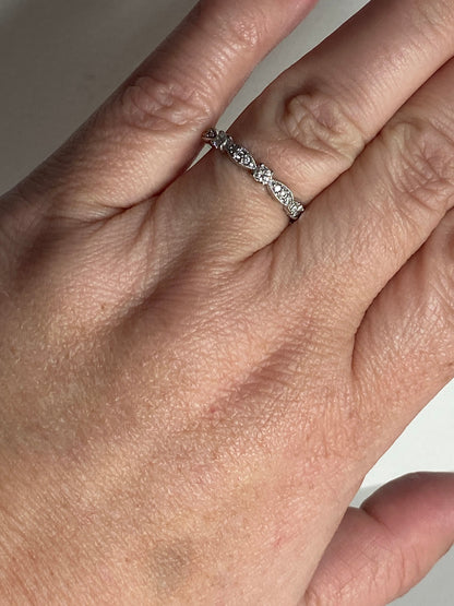 A delicate 10k white gold band ring with small diamonds.