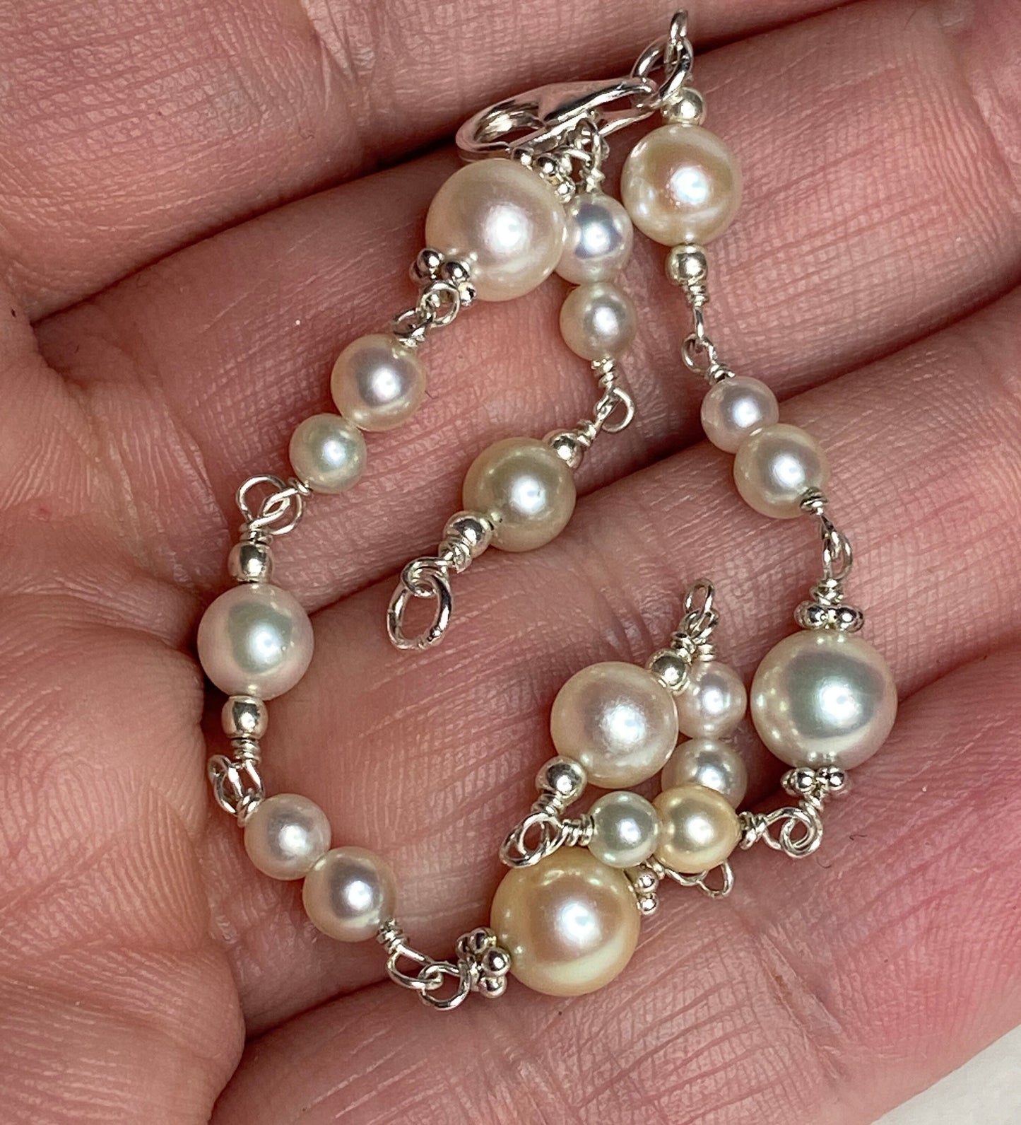 Sterling silver bracelet with multi-colored cultured Akoya pearls of varying sizes.
