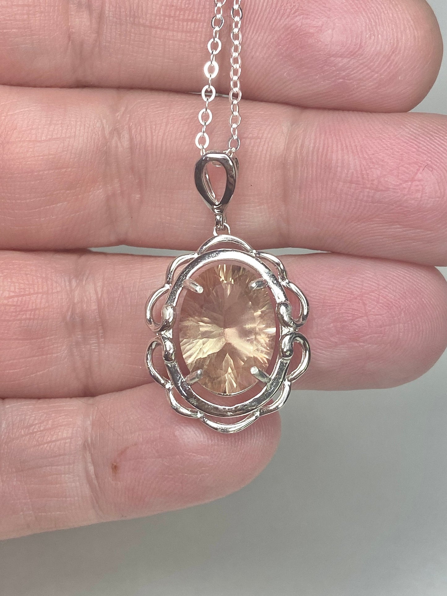 Sterling silver pendant necklace featuring a large oval fancy cut Oregon Sunstone.