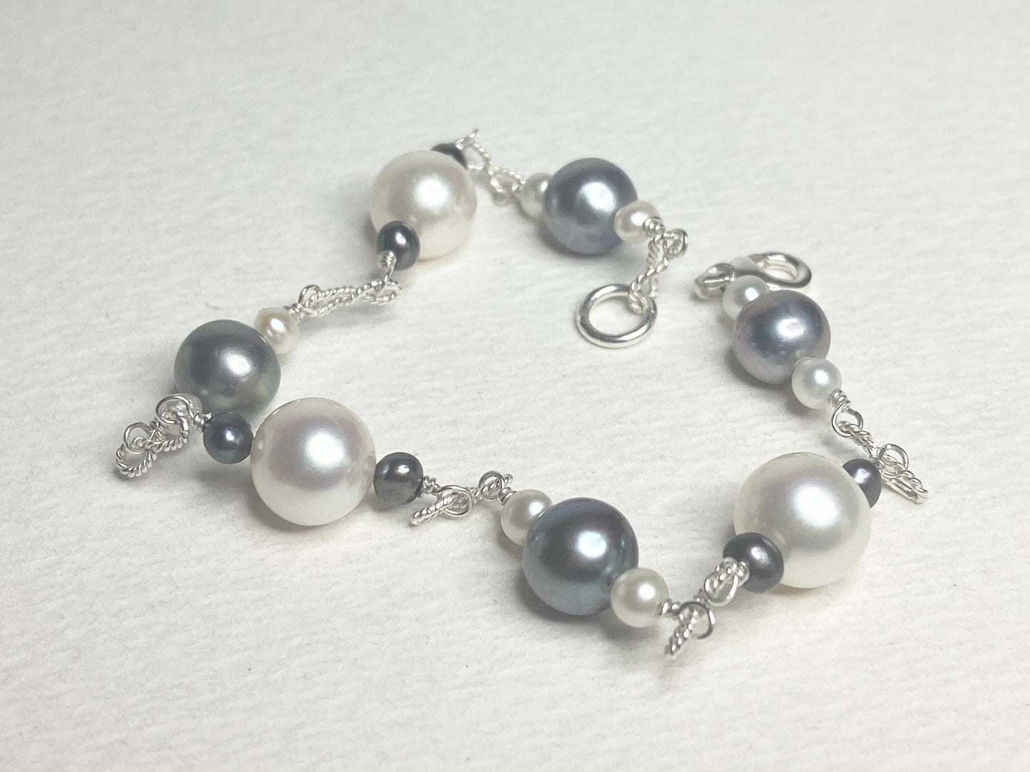 Sterling silver bracelet with Akoya, Tahitian, and freshwater pearls in black and white.