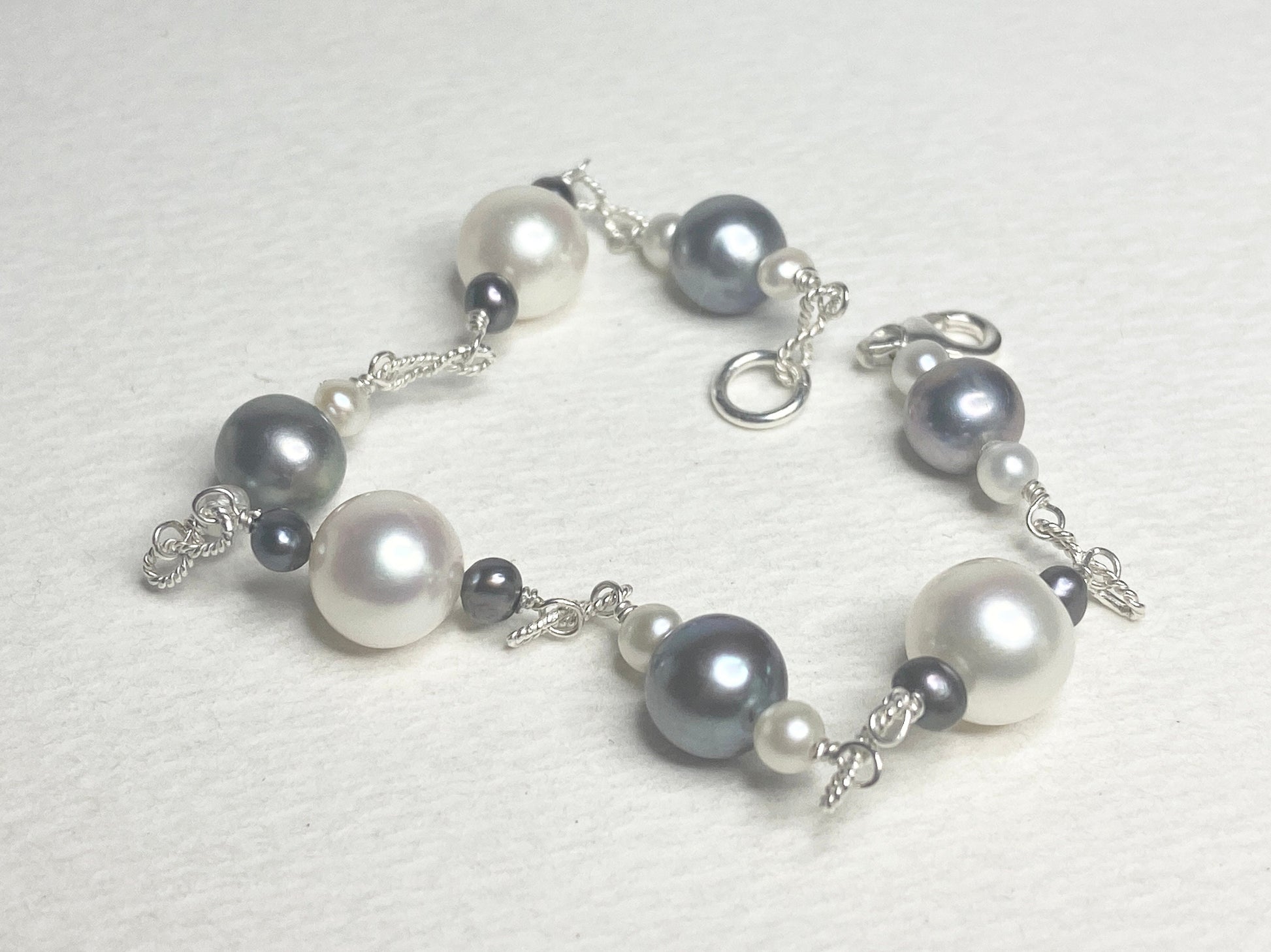Sterling silver bracelet with Akoya, Tahitian, and freshwater pearls in black and white.