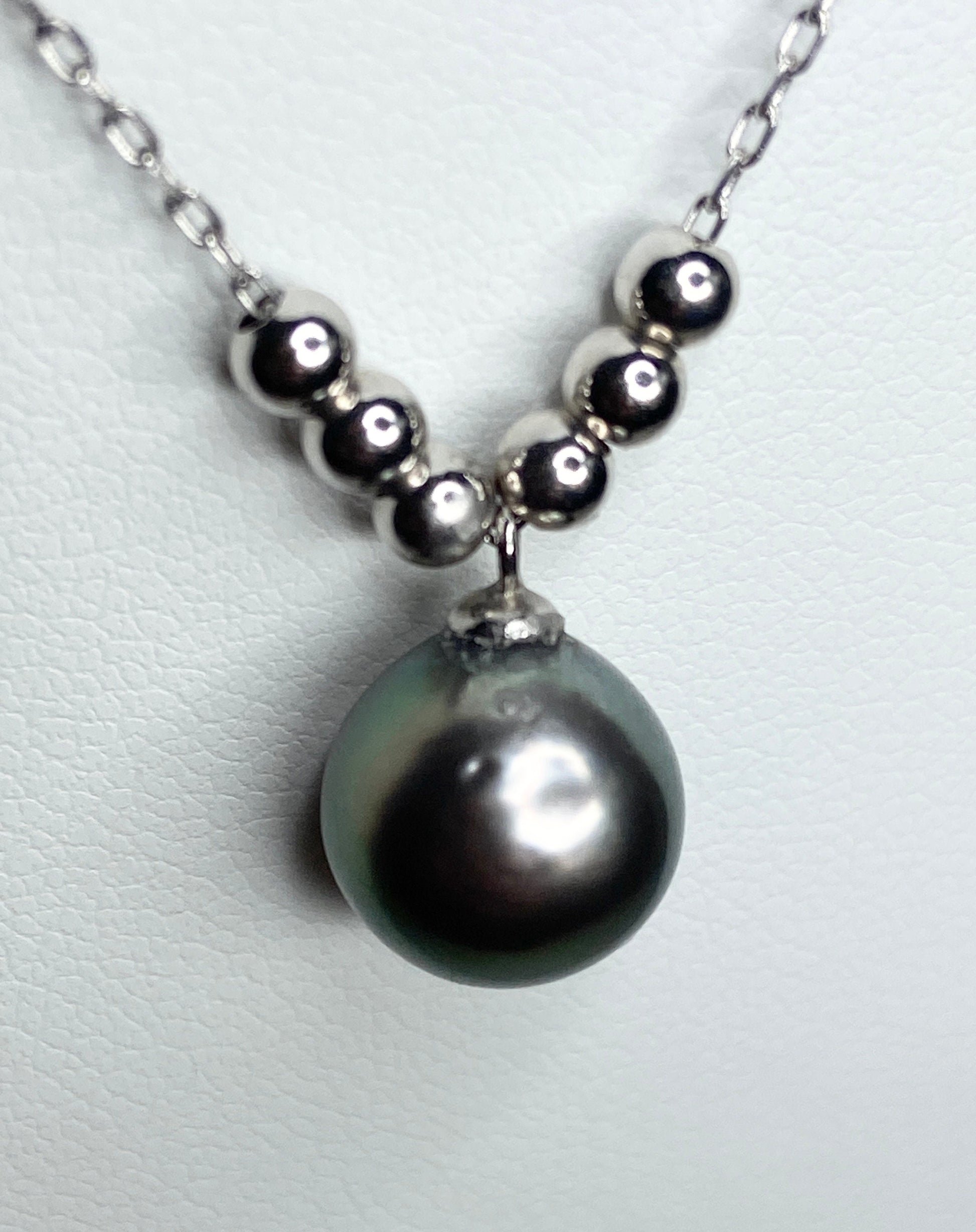 Sterling silver necklace with a Tahitian pearl pendant and floating beads.