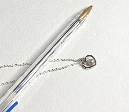 Sterling silver necklace with a double heart pendant and a 5mm cultured pearl.