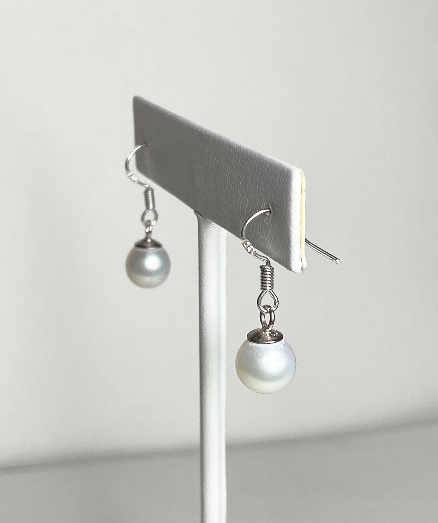 Sterling silver dangle earrings with 8mm white freshwater pearls.