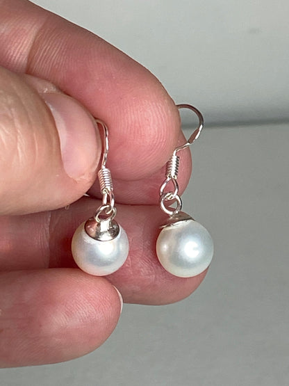 Sterling silver dangle earrings with 8mm white freshwater pearls.