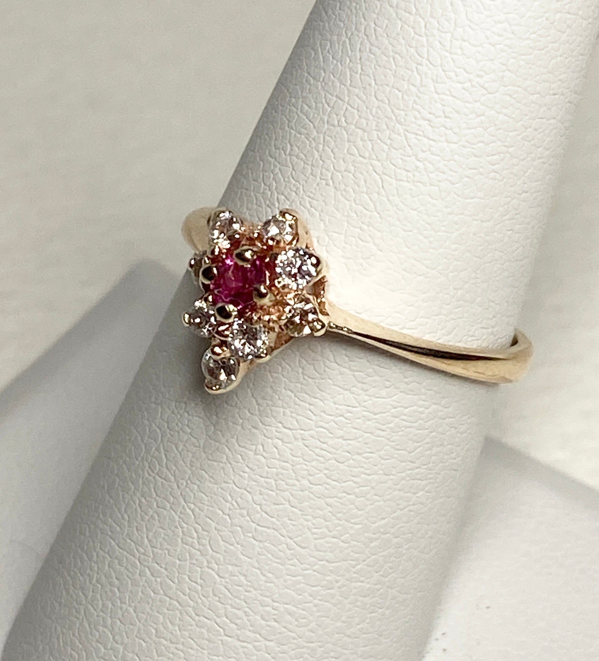 A 14k gold ring with a rubellite tourmaline and diamonds.