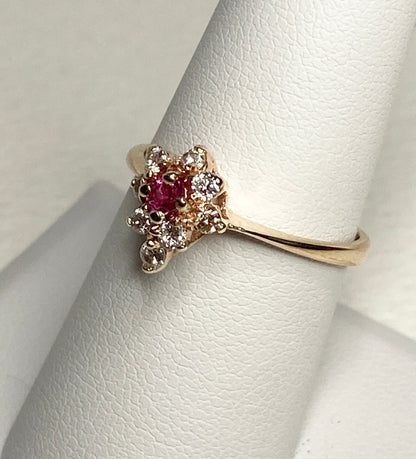 A 14k gold ring with a rubellite tourmaline and diamonds.