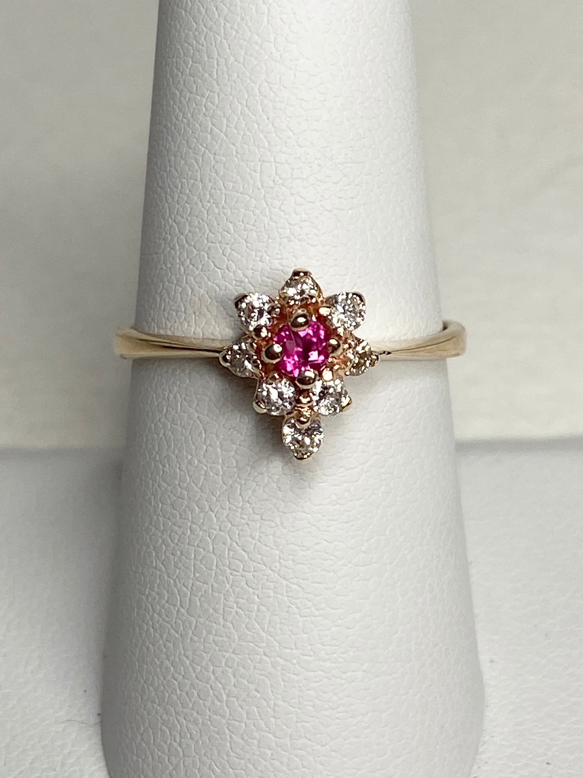 A 14k gold ring with a rubellite tourmaline and diamond cluster.